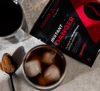 Instant Danger coffee package with a cup of iced coffee on a counter