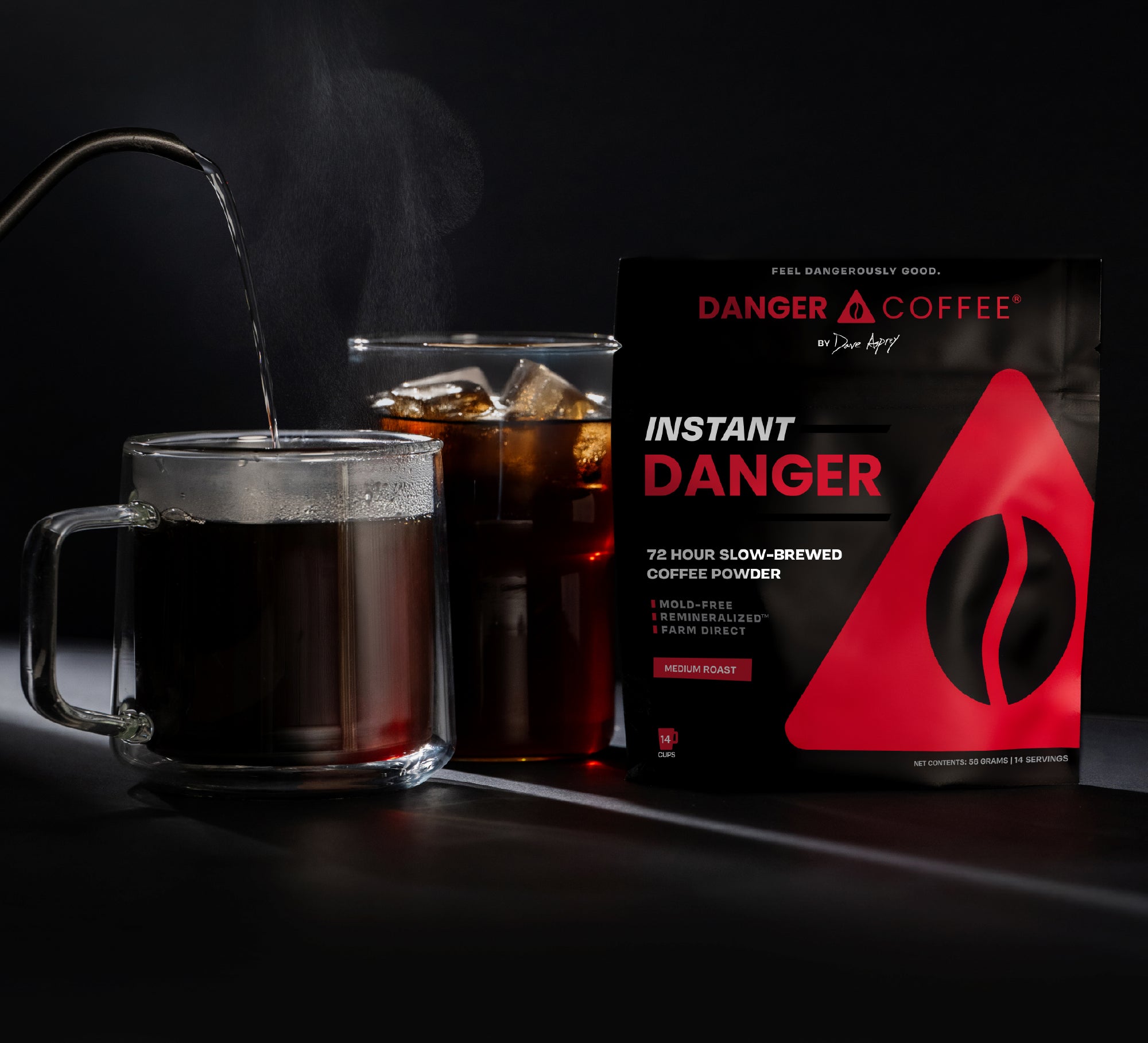 Glass mug with steaming coffee, bag of instant coffee powder, and 'Danger Coffee' packaging on a dark background.